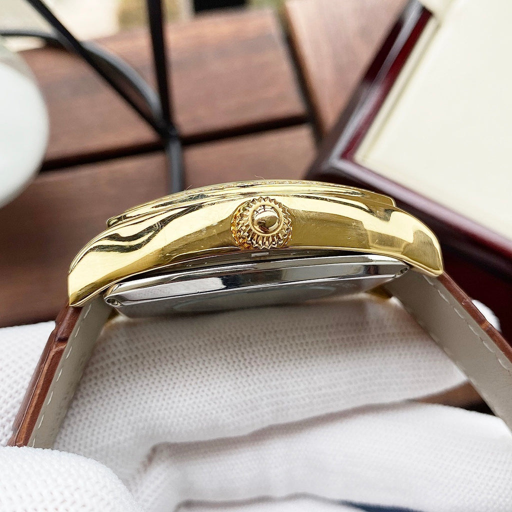 Wristwatch side view with gold-tone case and polished metal crown