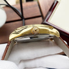 Wristwatch side view with gold-tone case and polished metal crown