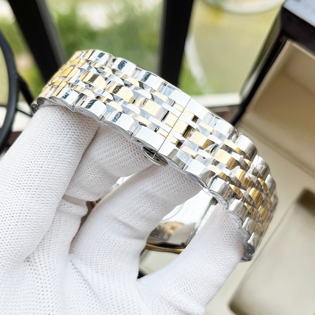 Two-tone metal watch bracelet with alternating silver and gold links, clasp visible.