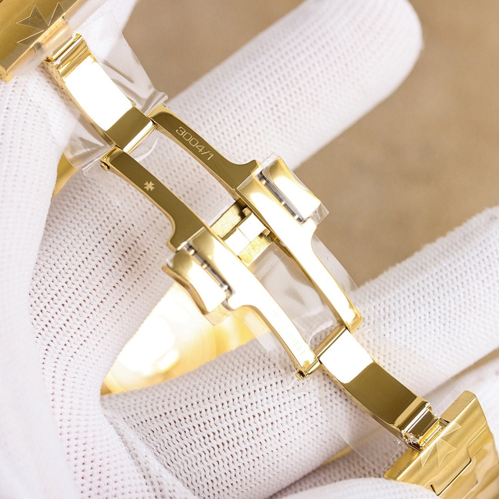 Gold watch bracelet links on a black strap, shown close-up on the wrist