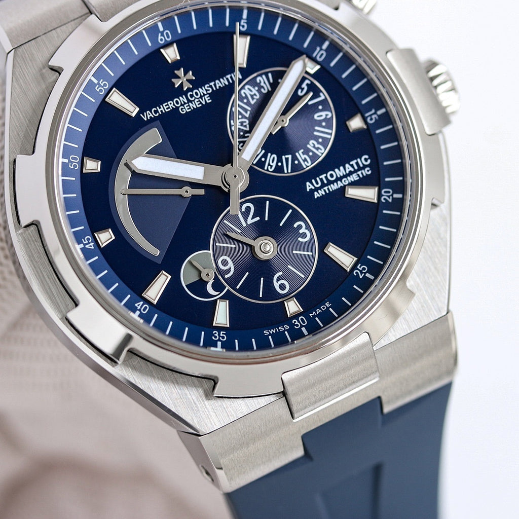 Men's automatic wristwatch close-up with blue dial, steel case, blue rubber strap