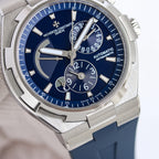 Men's automatic wristwatch close-up with blue dial, steel case, blue rubber strap