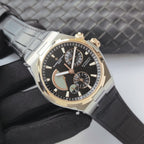 Vacheron Constantin watch with black dial, gold accents, and light gray leather strap