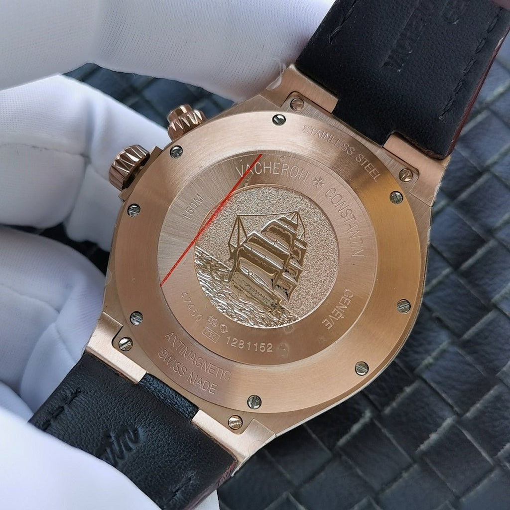 Gold-tone caseback with engraved emblem on dark leather strap