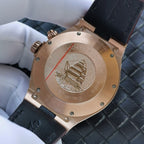 Gold-tone caseback with engraved emblem on dark leather strap