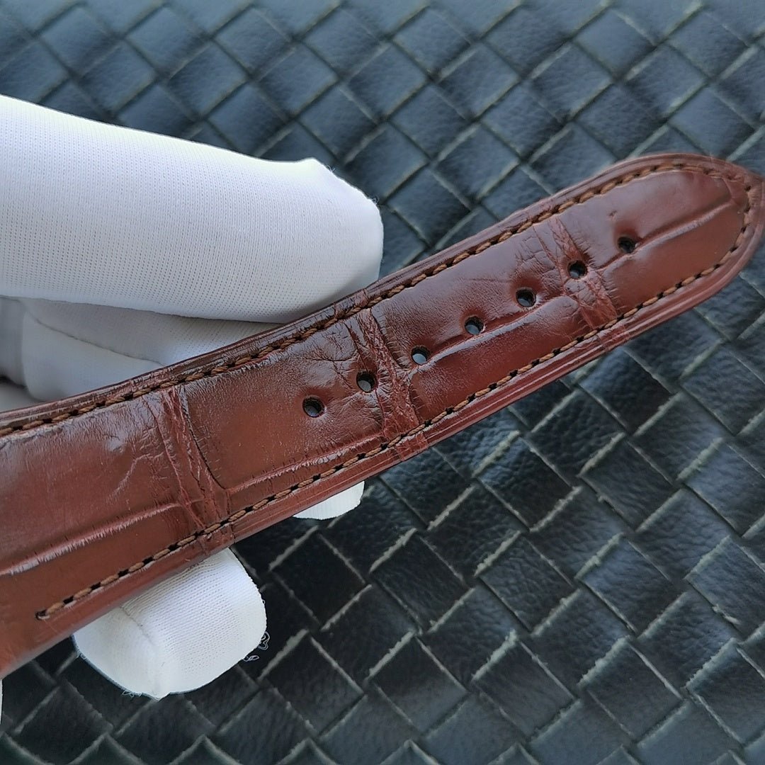 Brown leather watch strap with stitched holes and buckle end