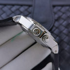 Stainless steel watch case with side details and dark leather strap