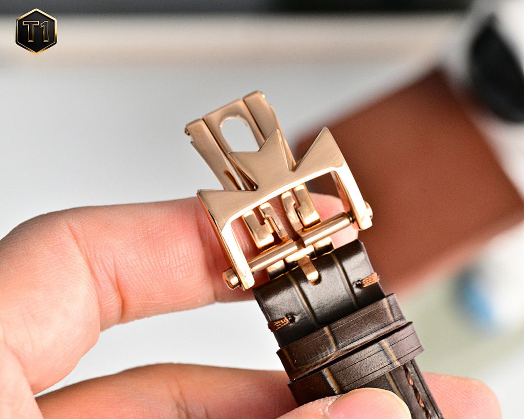 Rose gold deployment buckle wristwatch with brown leather strap, underside view