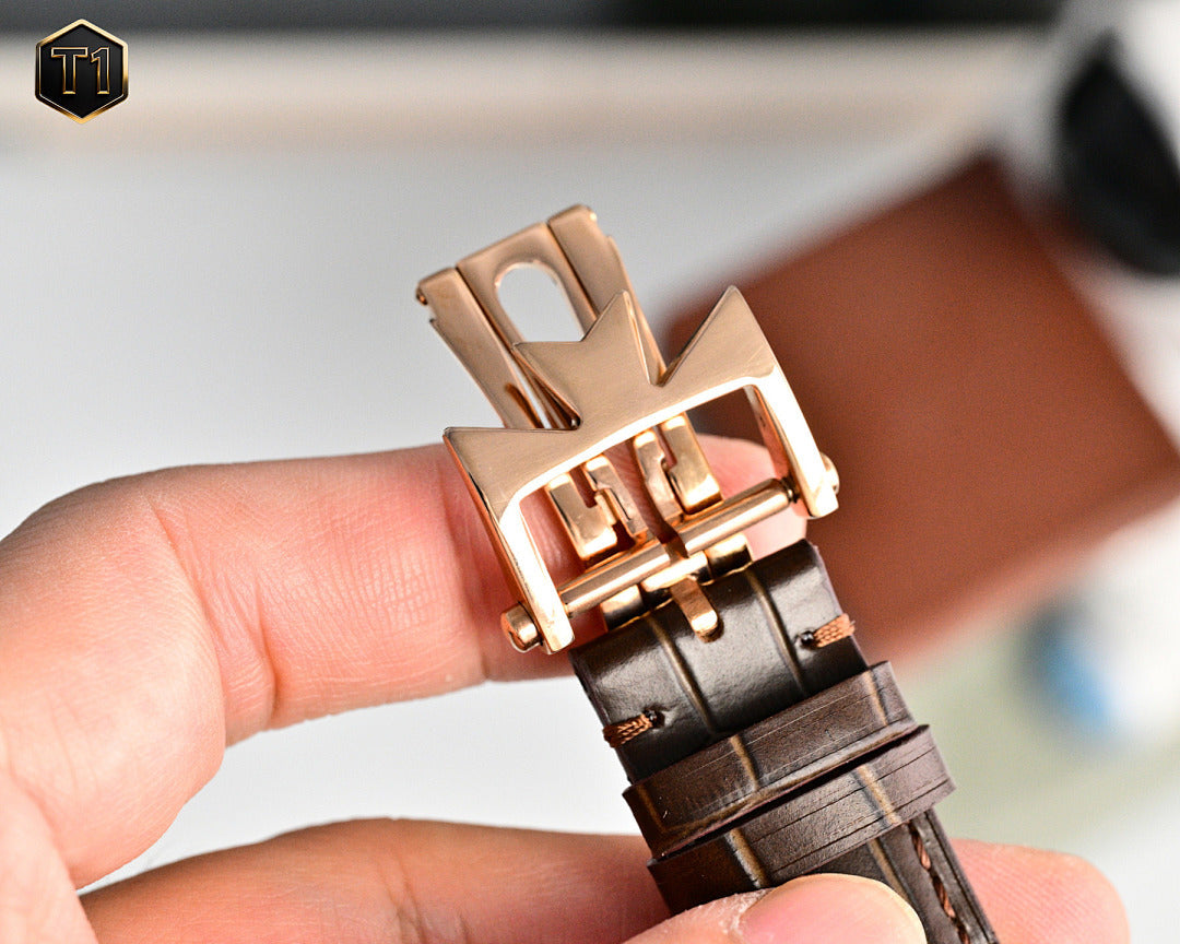 Rose gold deployment buckle wristwatch with brown leather strap, underside view