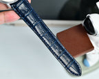 Blue leather watch strap with stitched texture, held up for a close-up view.