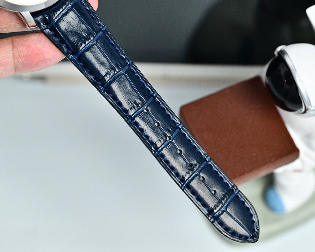Blue leather watch strap with stitched texture, held up for a close-up view.
