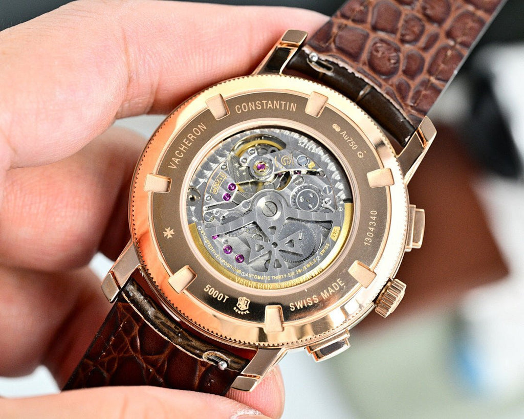 Vacheron Constantin watch caseback showing movement, brown leather strap and gold-tone bezel
