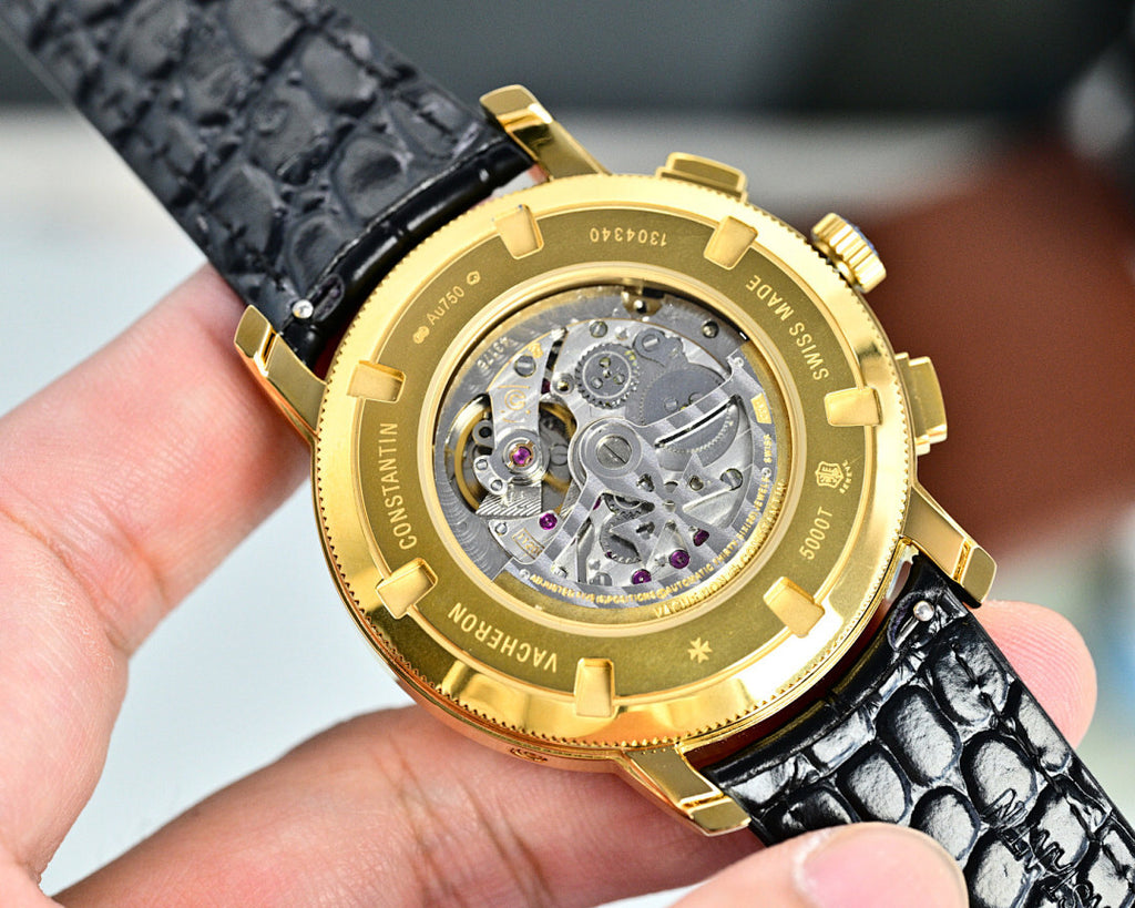 Gold-tone wristwatch case with see-through sapphire back, black leather strap