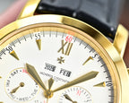 Gold-tone wristwatch dial close-up with date markers and FEB 2025, black leather strap