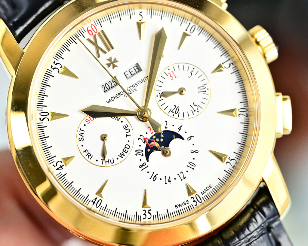 Gold-tone wristwatch dial close-up with subdials, date window, and FEB motif