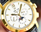 Gold-tone wristwatch dial close-up with subdials, date window, and FEB motif