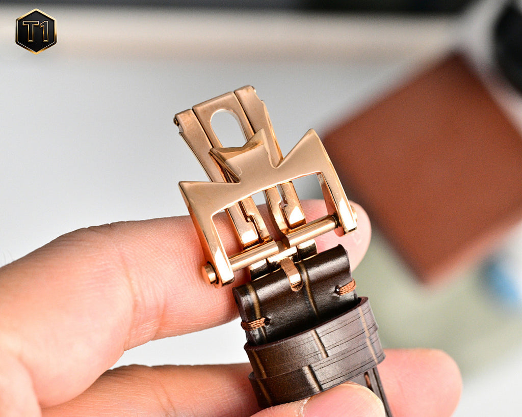 Rose-gold buckle and clasp on brown leather watch strap