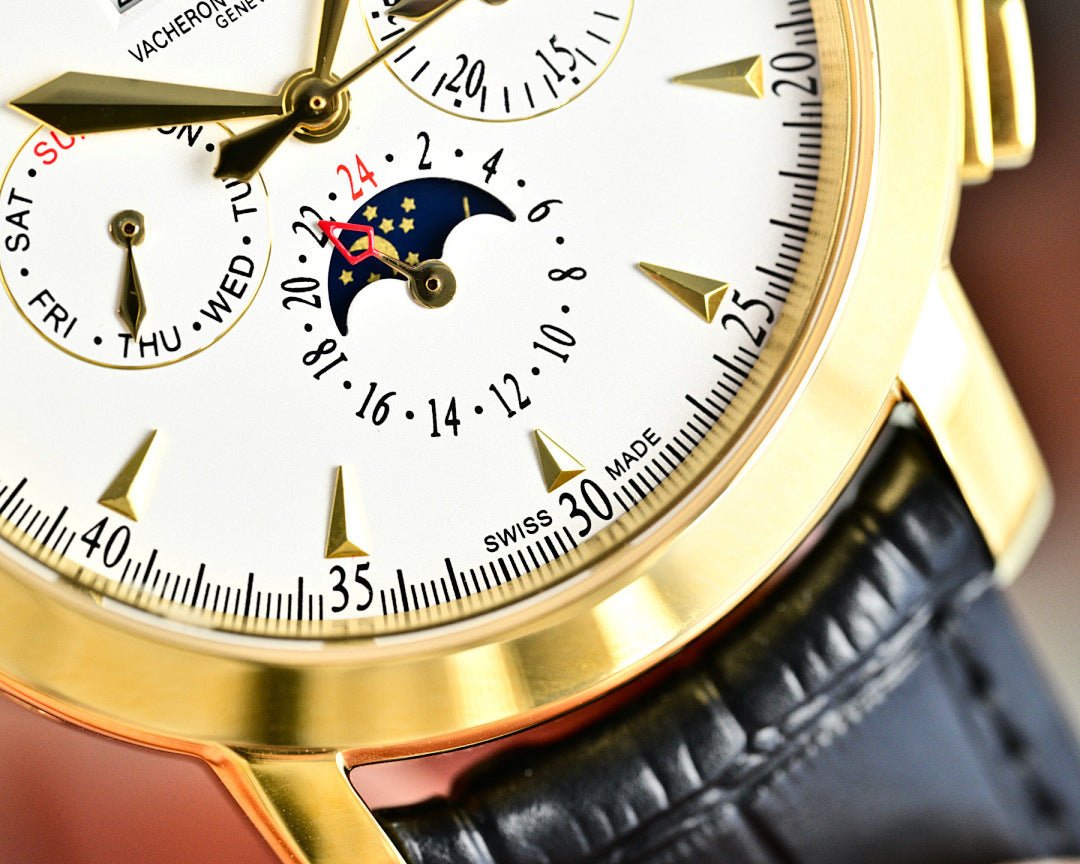 Close-up of watch dial with Roman numerals, gold bezel, black leather strap edge