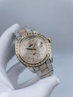Rolex watch with jeweled dial, gold-tone hour markers, diamond bezel, and metal bracelet.