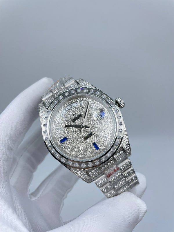 Rolex diamond bezel watch with silver bracelet and blue hour markers, angled view in hand