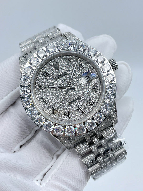 Diamond bezel wristwatch with dark dial, baton markers, and silver metal bracelet