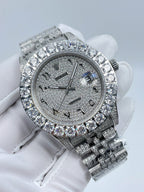 Diamond bezel wristwatch with dark dial, baton markers, and silver metal bracelet