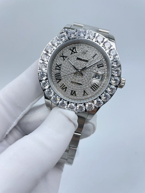 Rolex watch with silver dial, roman numerals, diamond bezel, metal bracelet