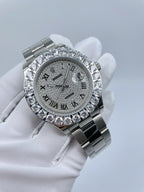 Diamond bezel watch with silver dial and metal bracelet held in glove
