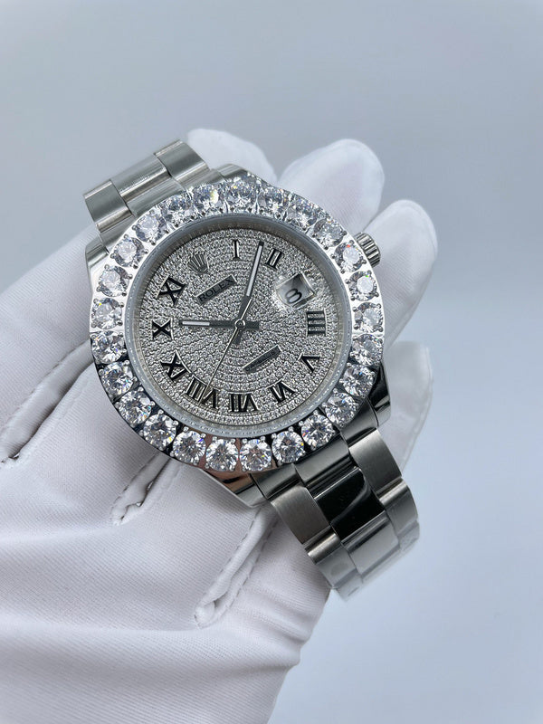Diamond bezel watch with silver dial and metal bracelet held in glove