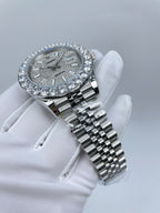 Rolex watch with diamond-set bezel, silver dial, silver link bracelet, angled view