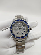 Rolex stainless steel watch with blue bezel, silver dial, and date window detail