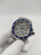 Rolex stainless steel watch with blue bezel and silver textured dial, view from front
