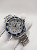 Rolex stainless steel watch with blue bezel and silver speckled dial on bracelet