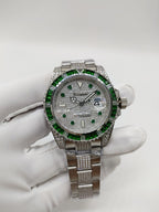 Rolex Submariner watch on glove, green bezel and dial accents, silver metal bracelet