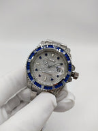 Stainless steel wristwatch with blue bezel, silver dial, and metal bracelet