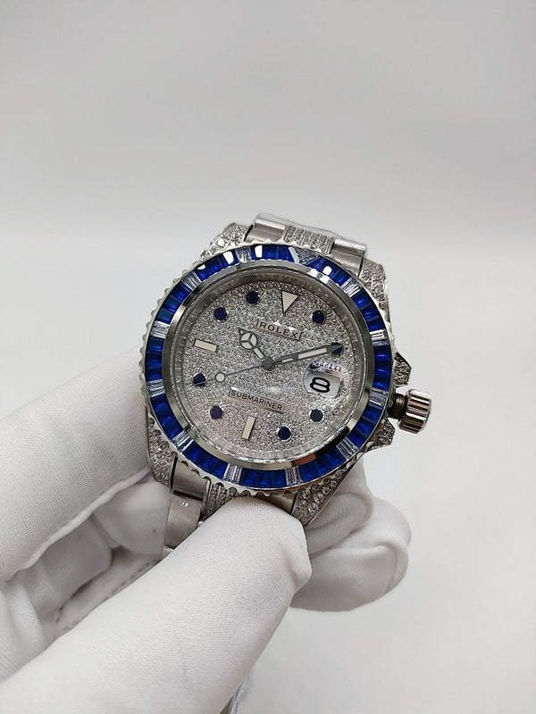 Stainless steel wristwatch with blue bezel, silver dial, and metal bracelet