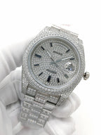 Diamond-set silver analog watch with jeweled bezel and day/date text on dial