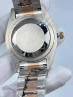 Rolex watch case back with polished stainless-steel finish and gold-tone crown