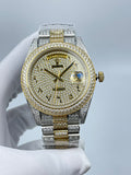 Rolex two-tone wristwatch with diamond bezel, gold accents, blue dial detail and metal bracelet.