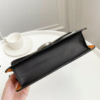 Coah bag top-handle clutch with black textured body and orange corner trims