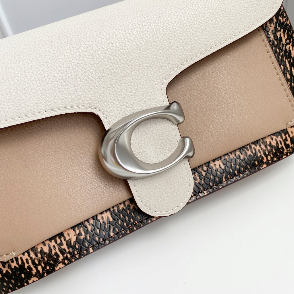 Coah bag close-up of front clasp and layered panels with light beige leather and patterned band.