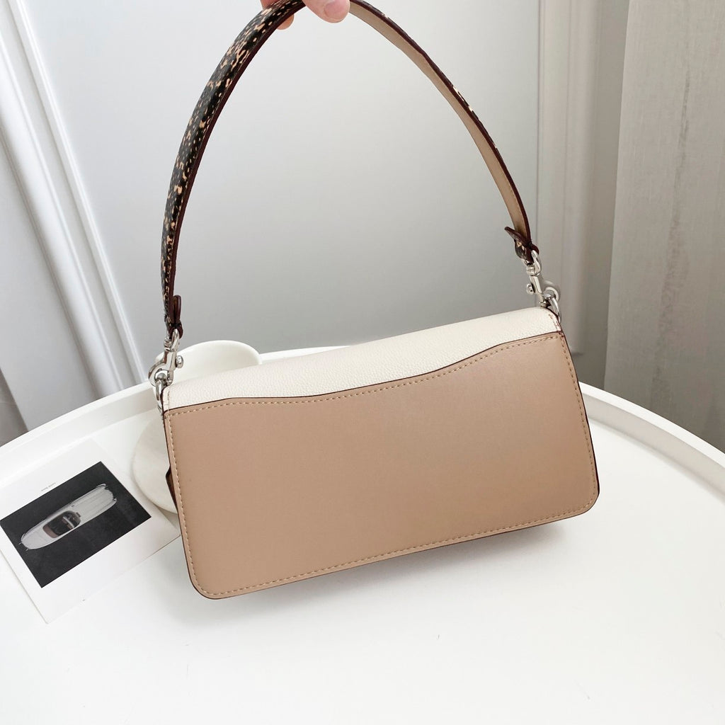 Coah bag front view with wide strap and smooth beige rectangular body with silver hardware.