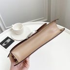 Coah bag long pouch profile with beige exterior, subtle side panel seams, and top edges.