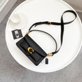 Coah bag black crossbody with flap, gold rings, and adjustable strap