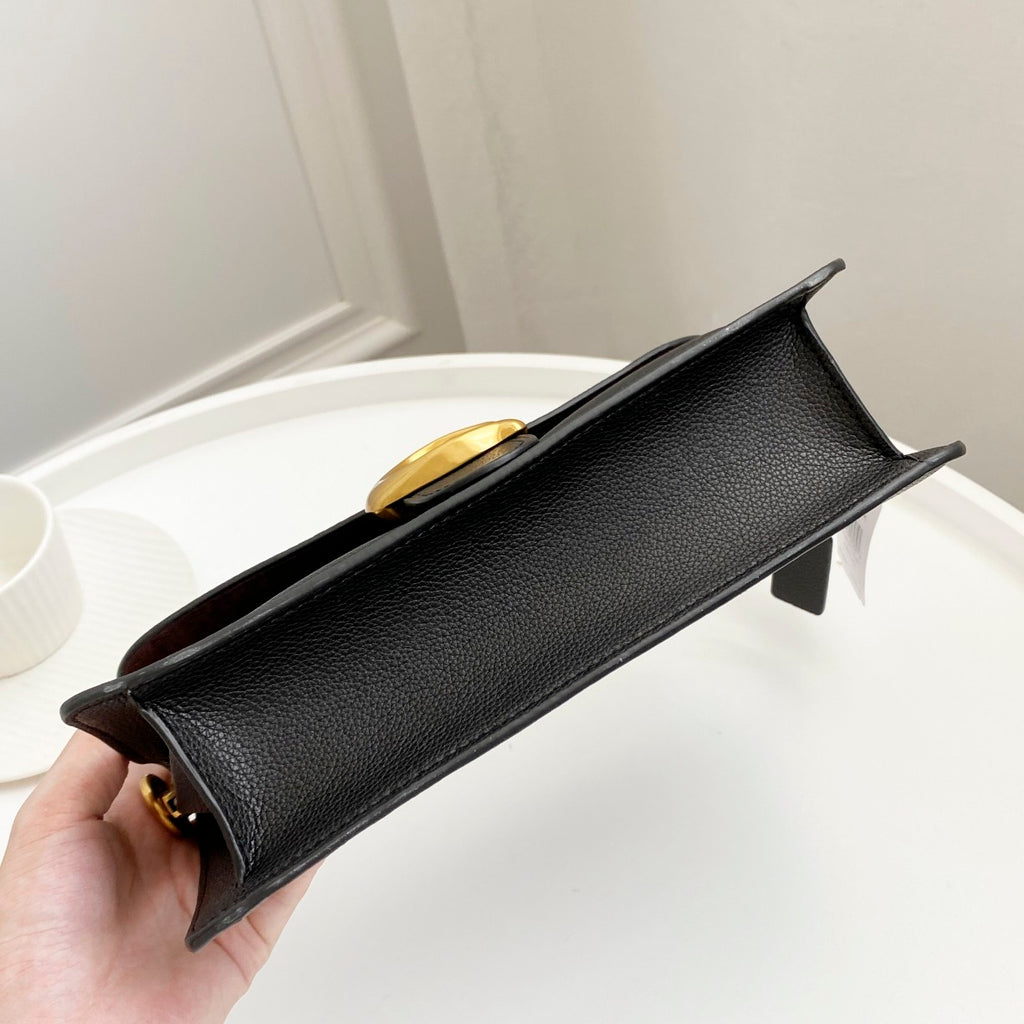 Coah bag black textured leather with gold top clasp and structured front flap
