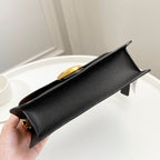 Coah bag black textured leather with gold top clasp and structured front flap