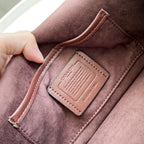 Coah bag burgundy suede with embossed logo patch on inner pocket