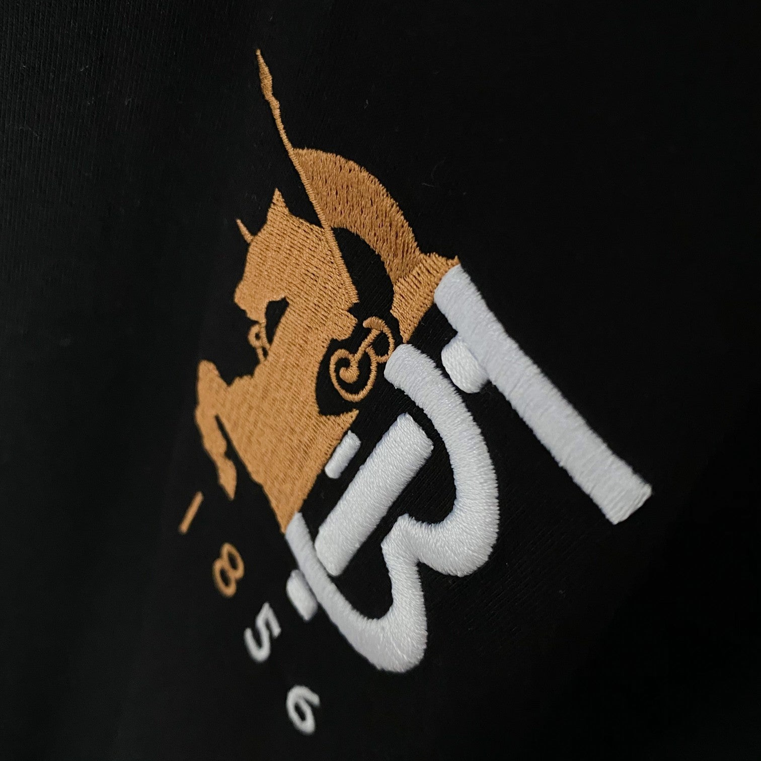Close-up of Burberry embroidered logo on black short-sleeve T-shirt