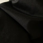Black T-shirt fabric close-up, smooth knit with subtle texture