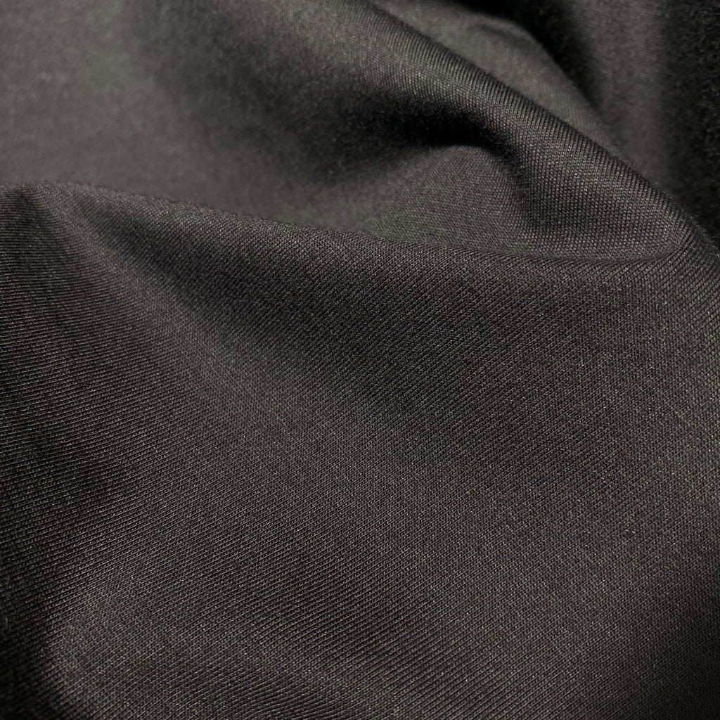 Dark T-shirt fabric close-up with fine woven texture